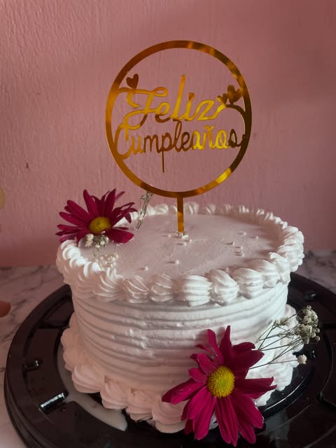 Pastel blanco de cumpleaños con flores doradas